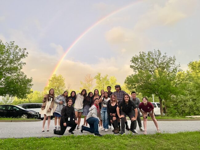 Students from the 2023 cohort of the Green Mountain Program pose under a rainbow