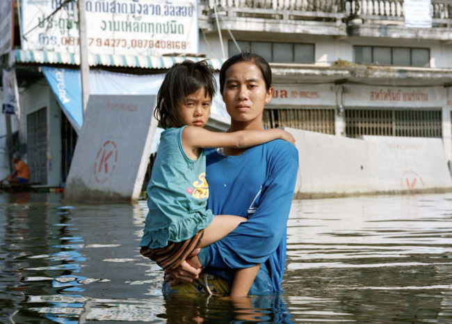 Excerpt from “Deluge” shows a family standing in floodwaters. Courtesy of Gideon Mendel