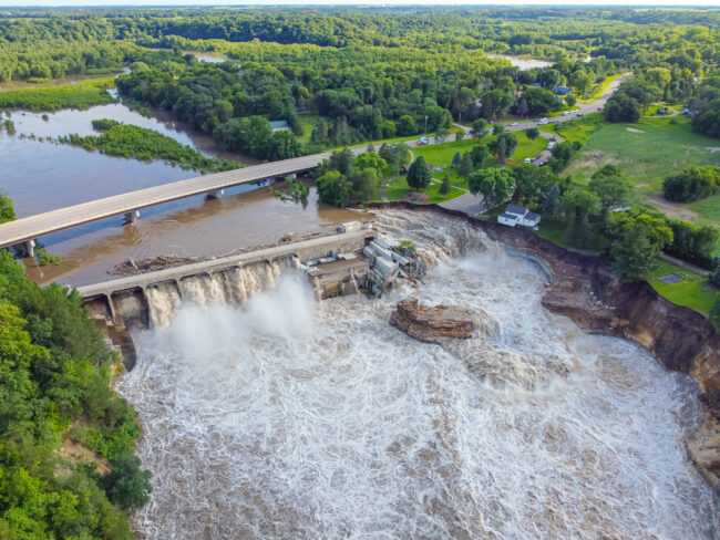 A dam with greenery surrounding it