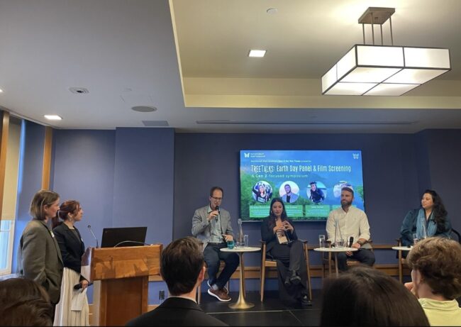 A panel of speakers in front of a screen